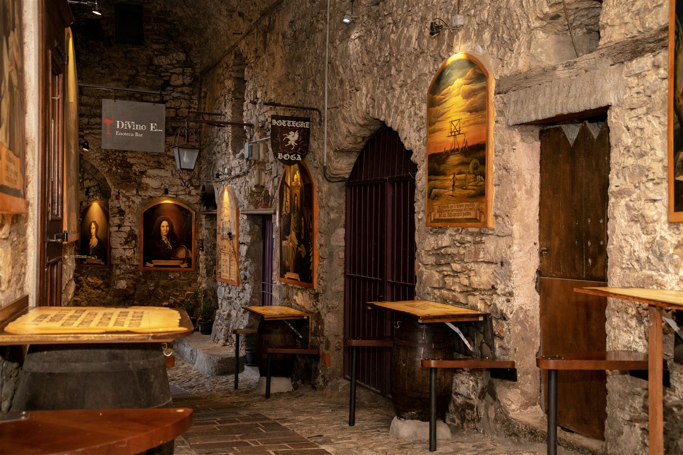 A dim medieval tavern, cups on a worn table, a single candle burning.